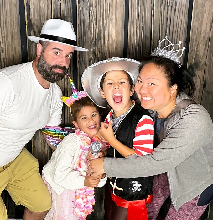 family with kids posing at photo booth party in Carson California