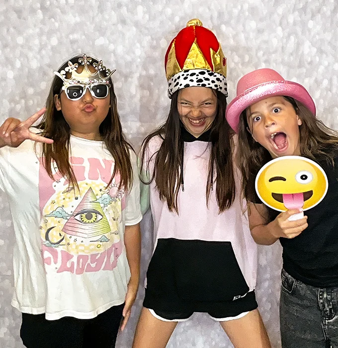 girls wearing crowns and party hats at photo booth in Carson California