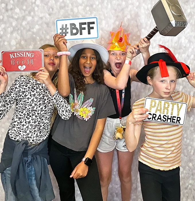 kids holding party crasher sign and funny props at photo booth in Carson California
