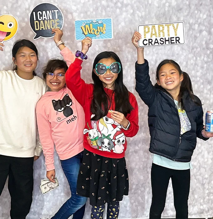 kids holding funny party props at photo booth in Carson California