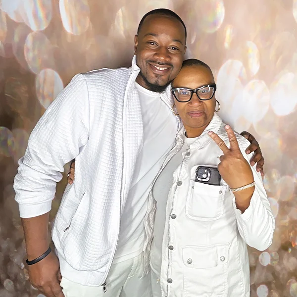 mother and son smiling and posing at birthday party photo booth in Carson California with peace sign