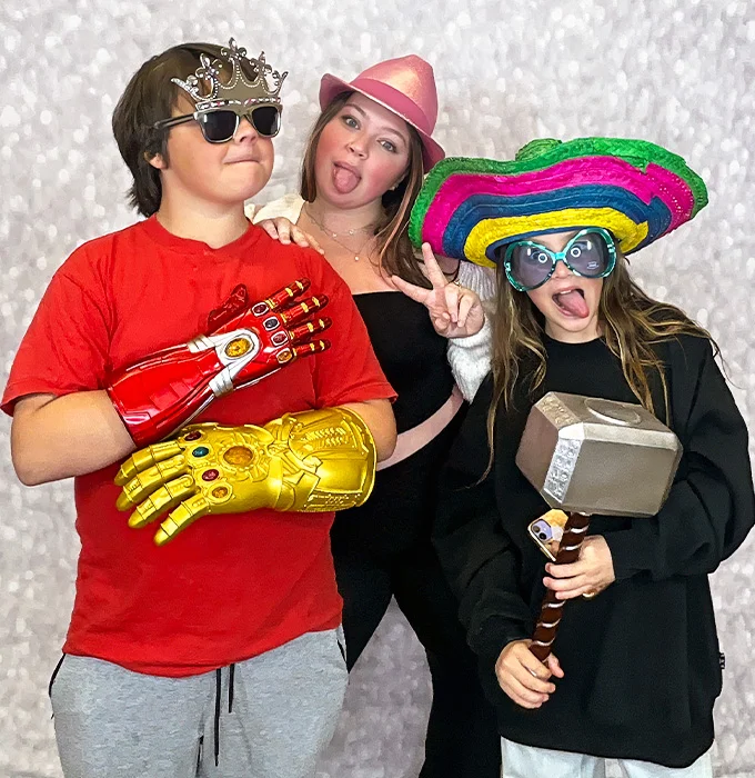 friends wearing sombrero hat and superhero props at photo booth in Carson California