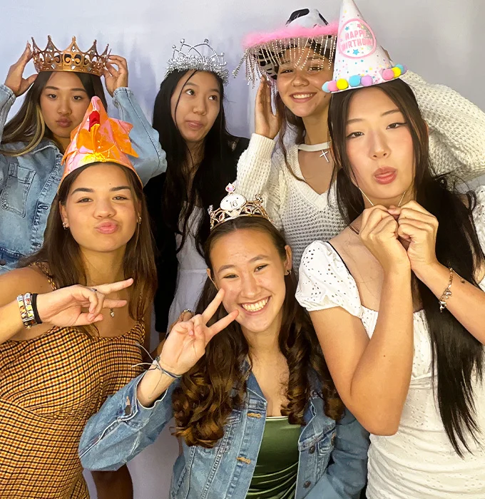 girls wearing crowns making peace signs at photo booth in Carson California