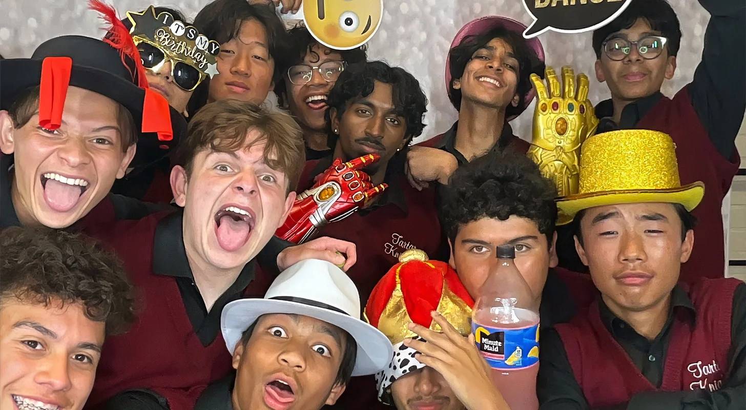 Large group of high school students having fun with a photo booth rental in Carson CA wearing silly props hats and birthday glasses