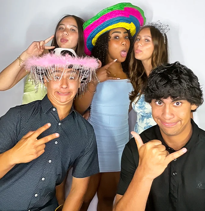 teen friends posing with hats and props at photo booth in Carson California